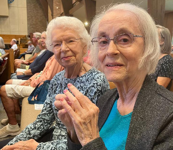 Joan Hanson (1932-2022), above right, attending a community event.