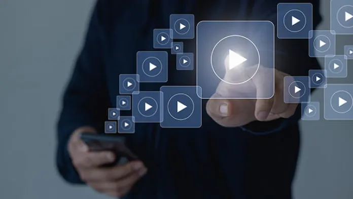 Person using a smartphone to select and play a video from an online streaming library.