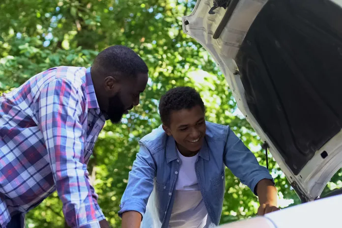Adult and youth working on a car