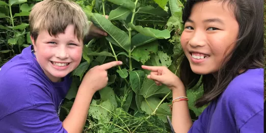 Two youth pointing at a chrysalis