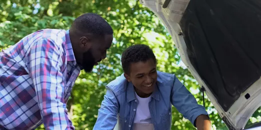 Adult and youth working on a car